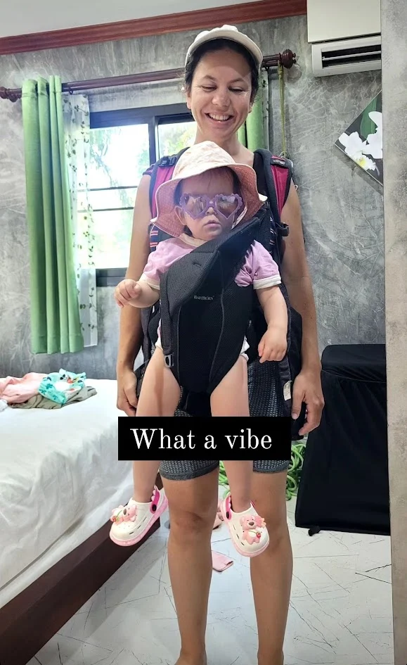 mum standing smiling with her daughter in a baby carrier in thailand