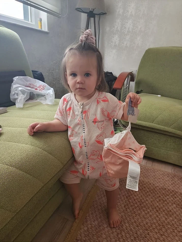 little girl holding up her first pair of knickers before toilet training