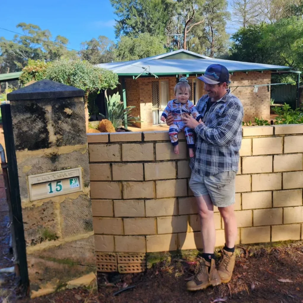 A dad and his daughter standing out front of their house for the last time, waving or hugging.