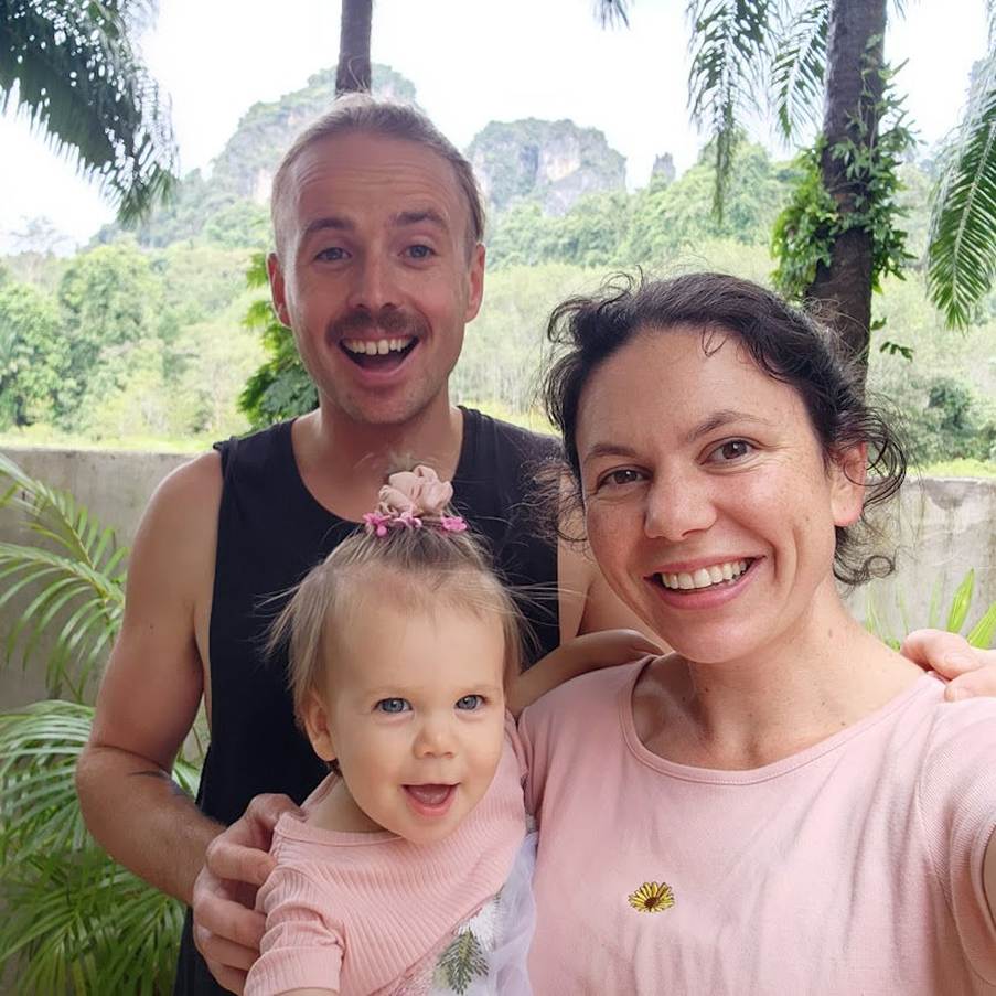mum and dad smiling holding their baby in thailand